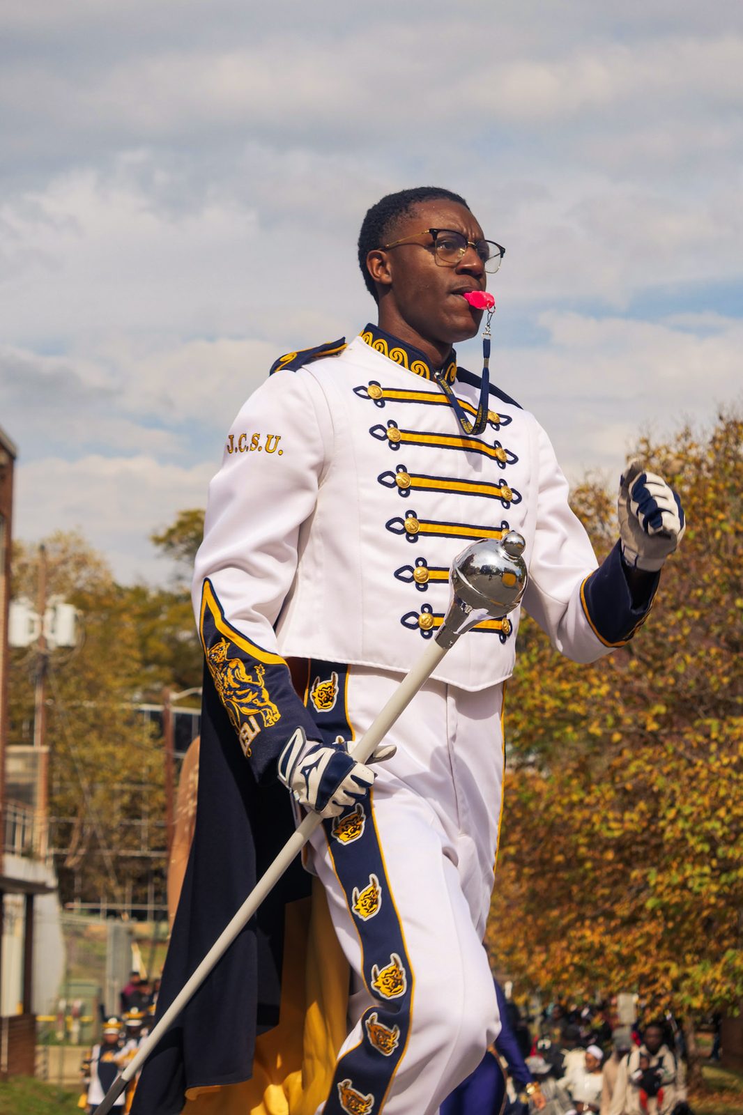 A JCSU drum major in dress whites carrying the mace
