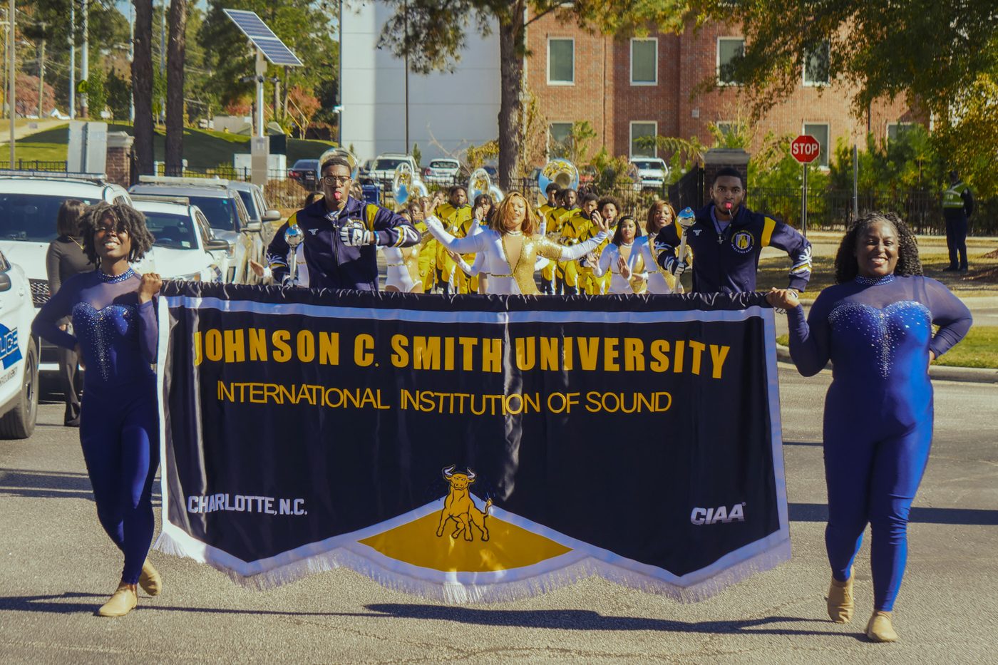 The band marching behind the university banner